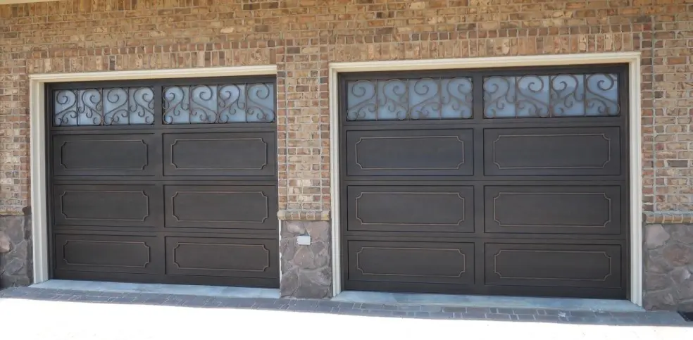 Two garage doors with a brick wall and stone floor.